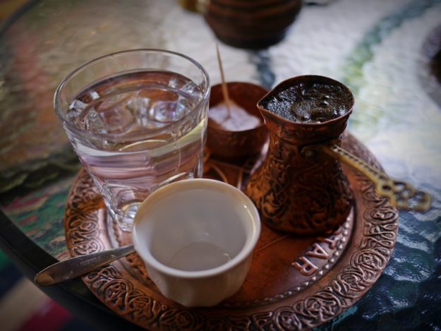 A picture of traditional Bosnian coffee served with water and turkish delight.