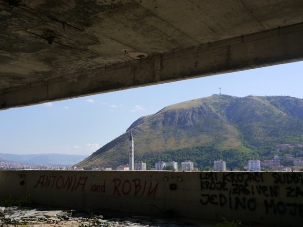 The cross overlooking the city of Mostar along with the church.