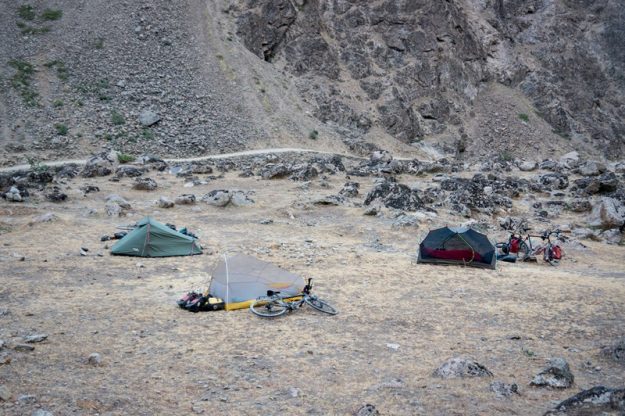 Our 3 tents pitched amongst some rocks in Tajikistan, with Afghanistan in the background